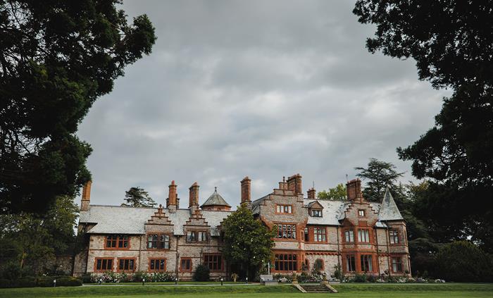 A hotel surrounded by trees on the ground of an estate